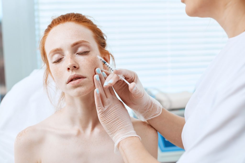 Woman receiving injection in her face (model)