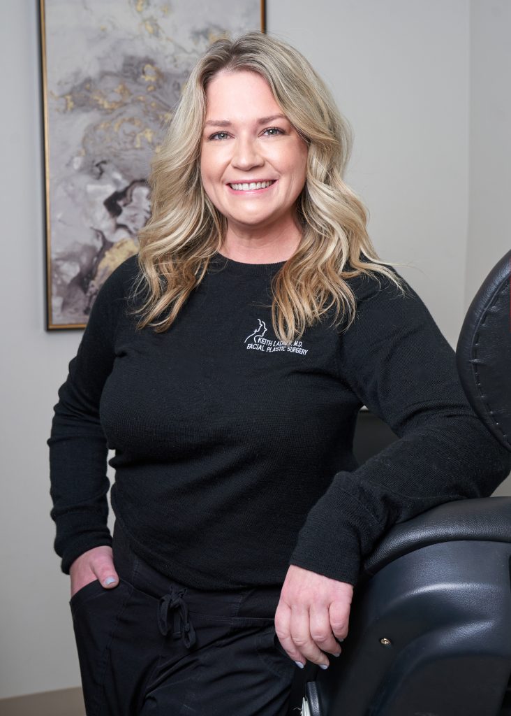 RN Mary wearing black Ladner Facial Plastic Surgery scrubs