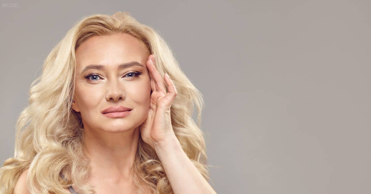 Woman with her hand touching her face (model)