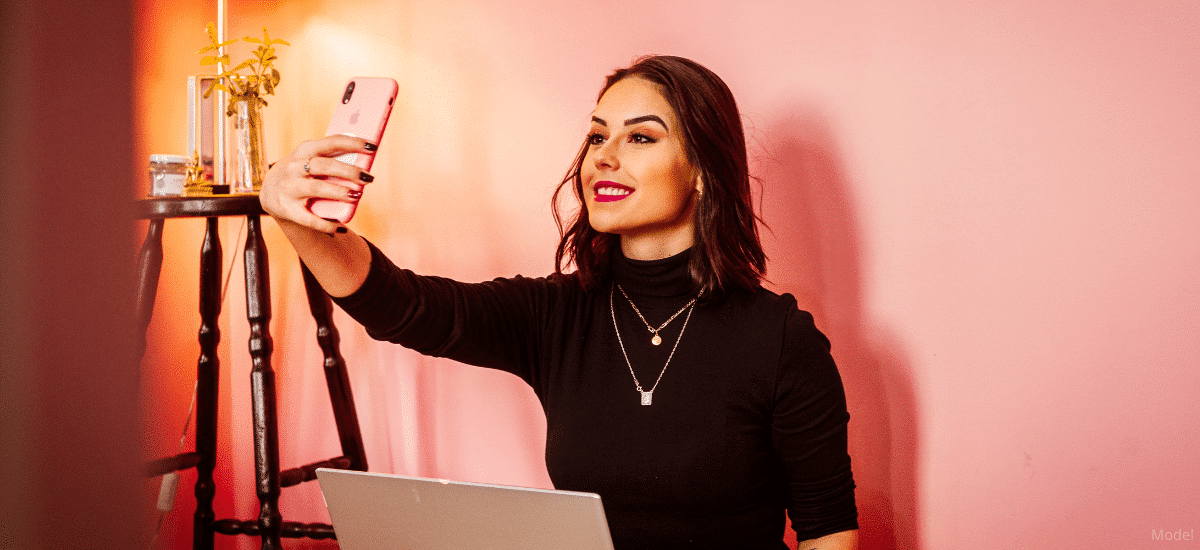 Woman taking selfie with her pink iphone