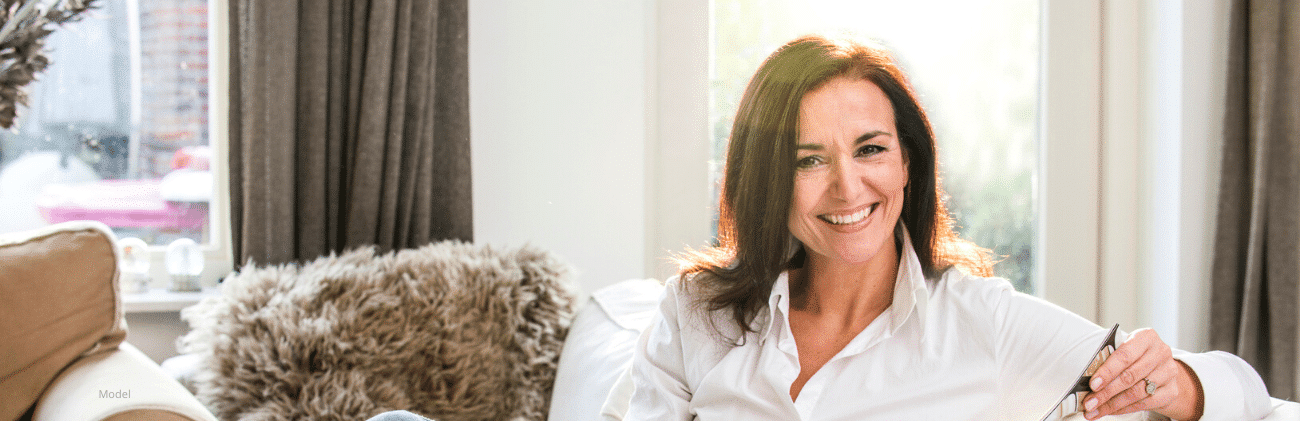 Woman sitting on couch reading magazine