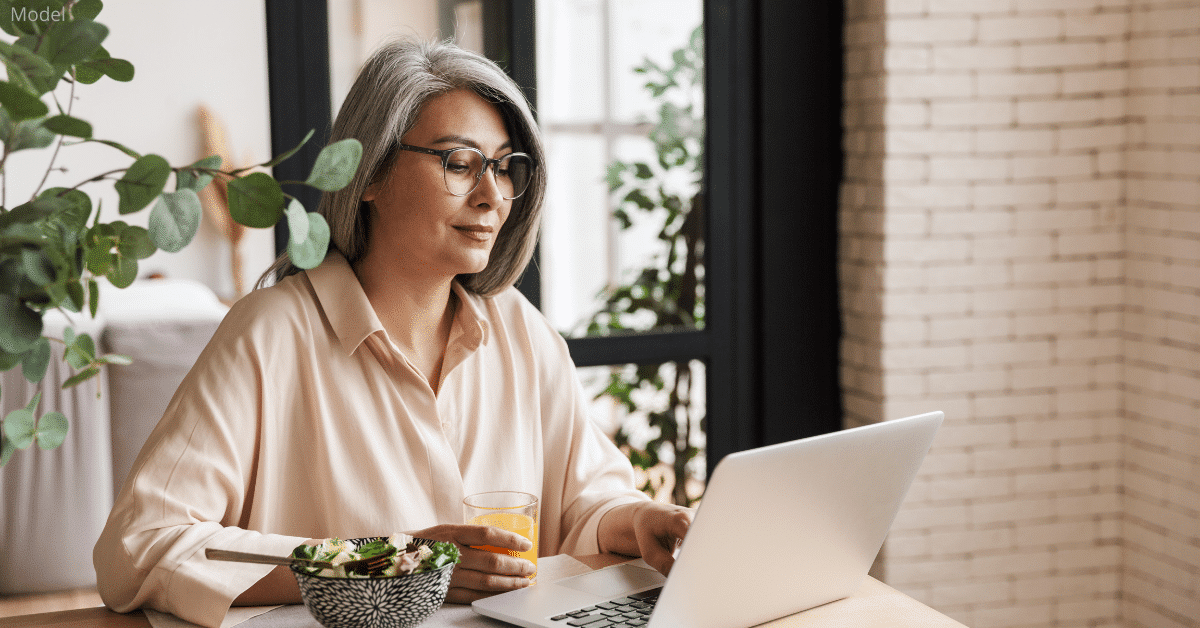 Woman researching blepharoplasty surgeons on the computer near Denver, CO