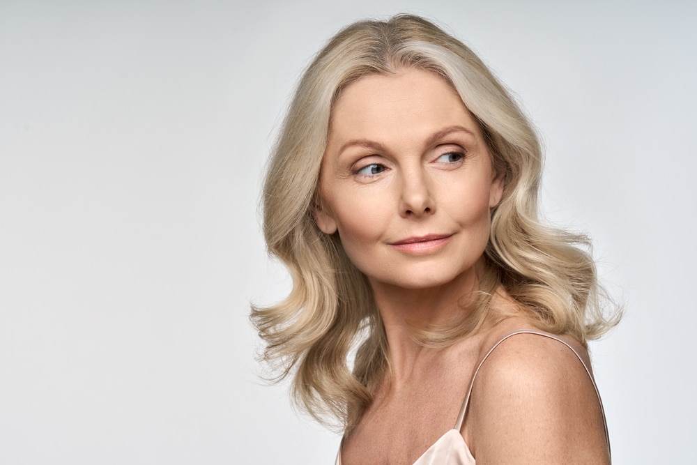 Middle aged woman has refreshed face after eyelid surgery.