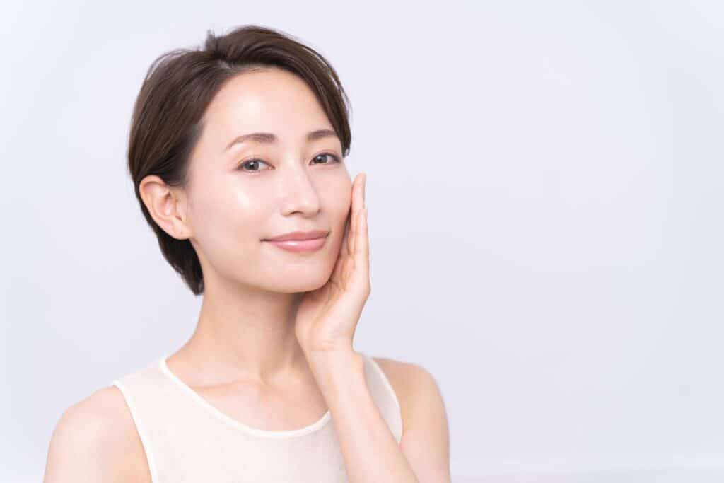 Asian woman touches her cheek, enjoying the new volume