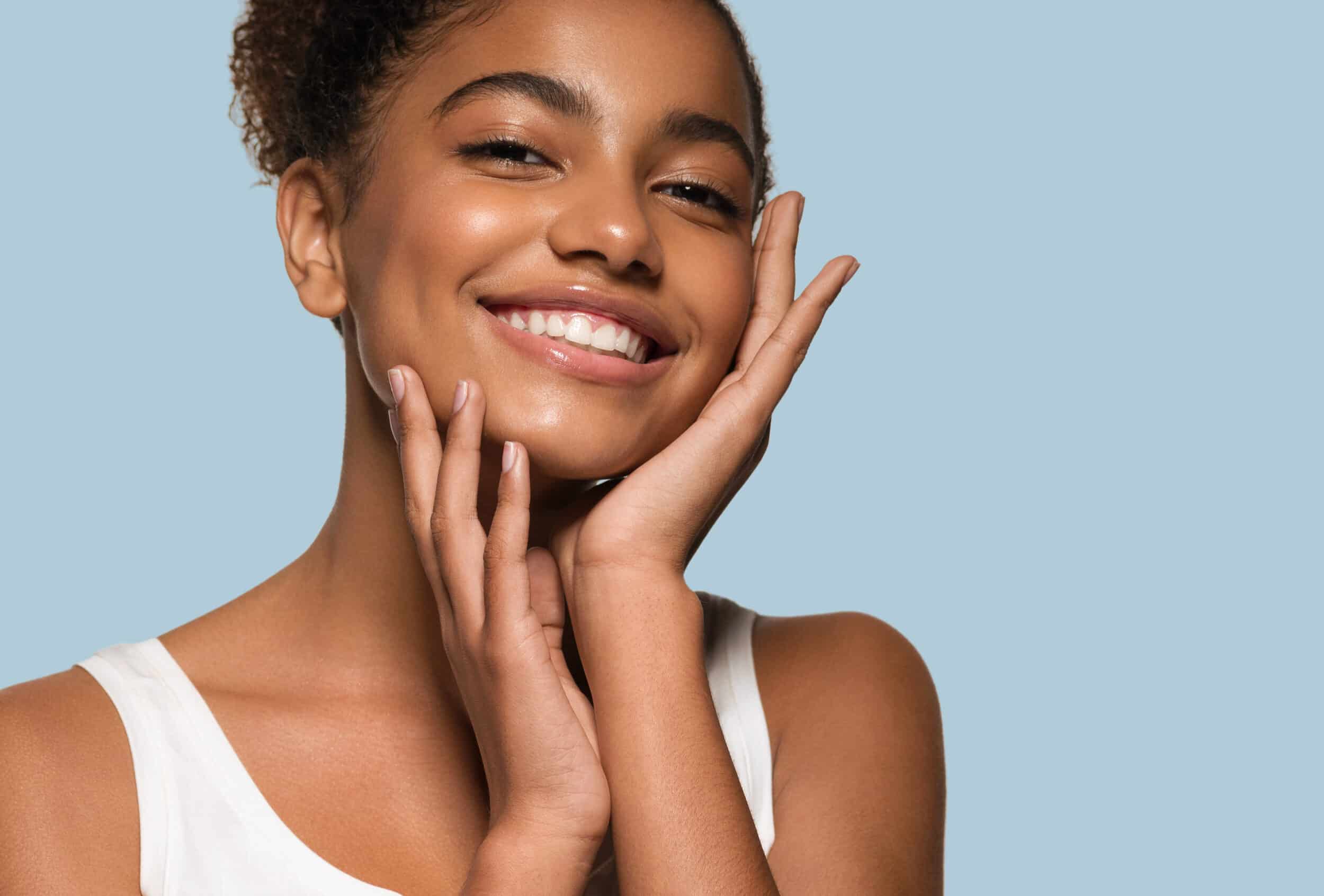 Beautiful young woman with shiny, bright skin after using medical-grade skincare treatments.